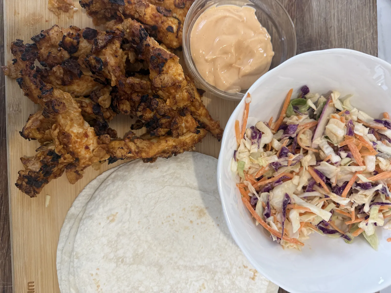 air fryer chicken tacos Crispy air fried chicken with chilli aioli, coleslaw and tortillas on a board