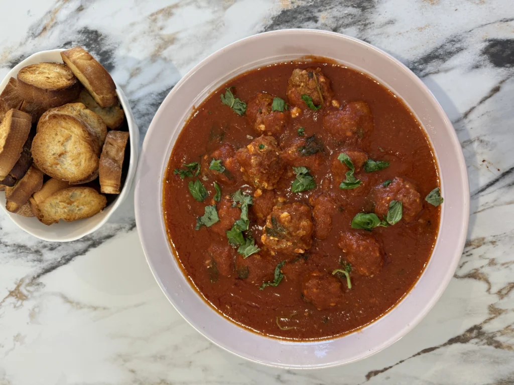 Cheesy baked meatballs in tomato sauce with crispy bread