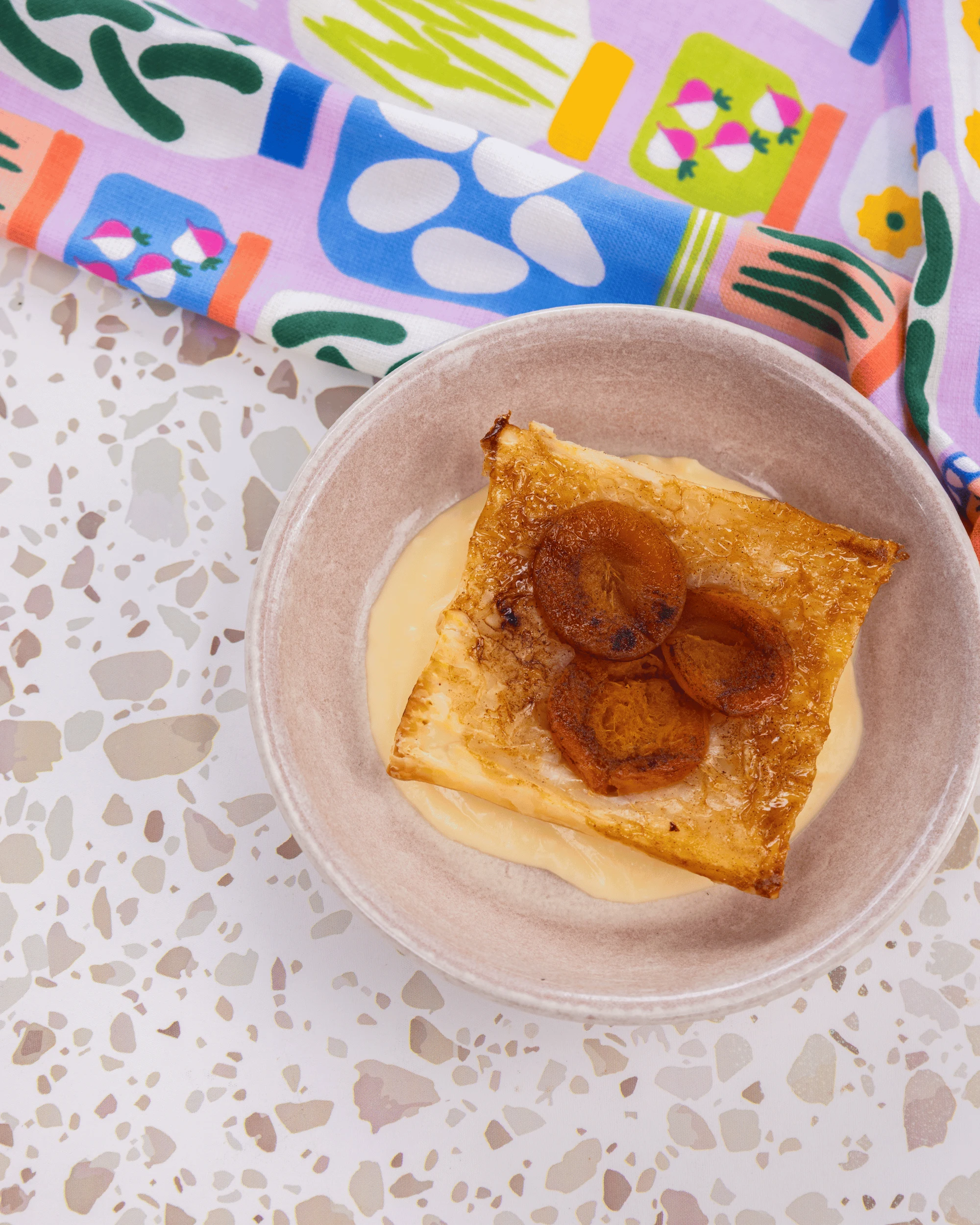 Upside down apricot pie served over vanilla custard