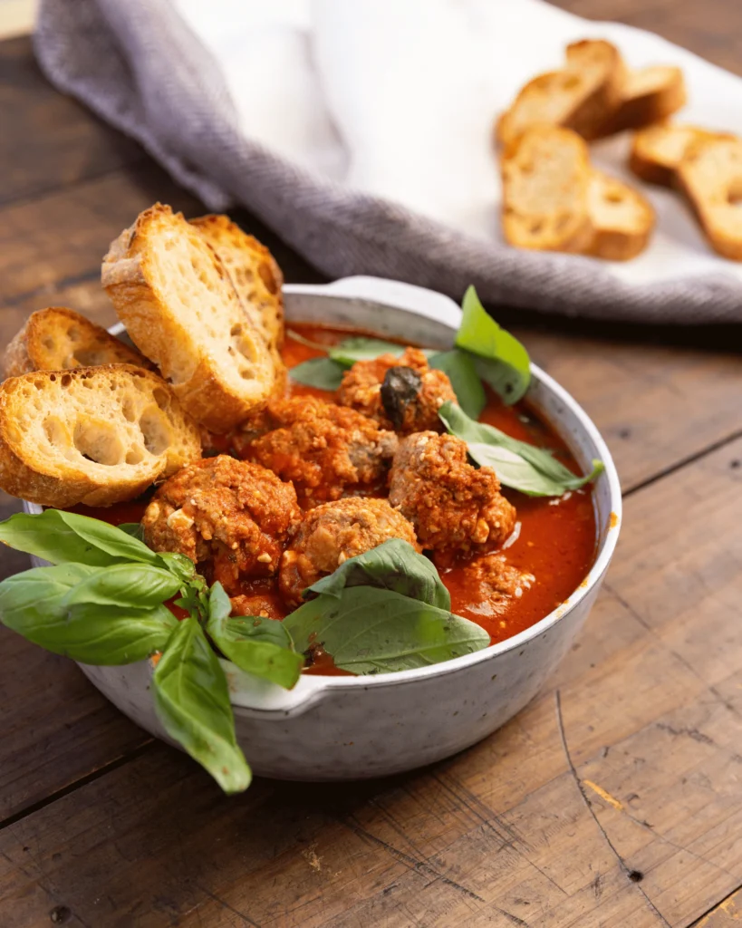 Cheesy meatballs baked in passata and served with crispy bread