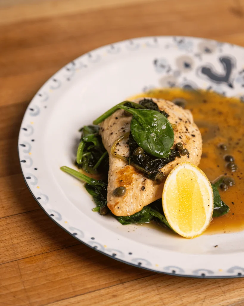 Chicken piccata with lemon butter sauce, capers and wilted spinach