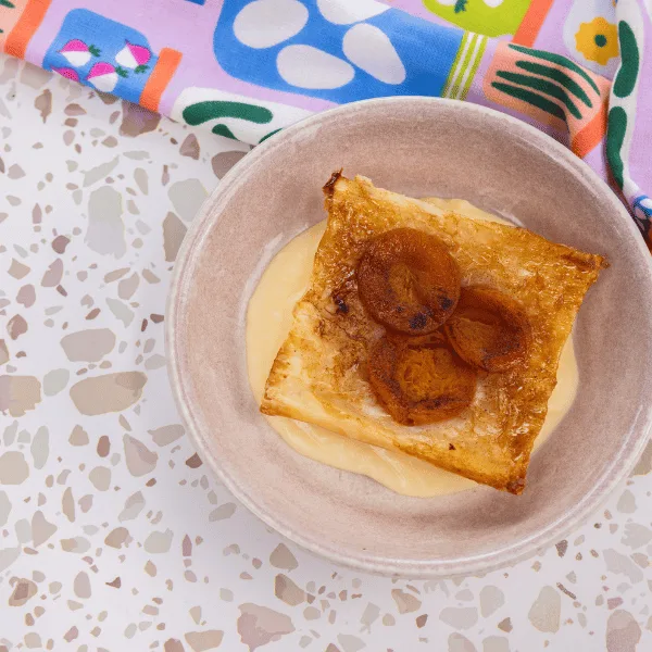 Upside down apricot pie served over vanilla custard