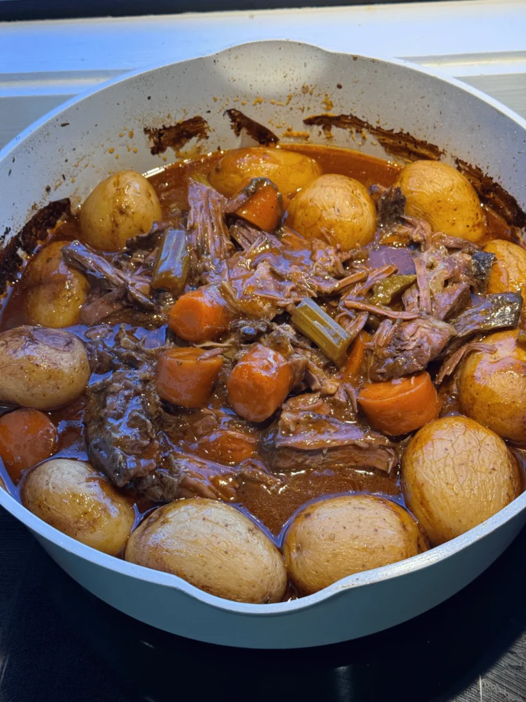 Pot roast with red wine gravy, carrots, celery and baby potatoes